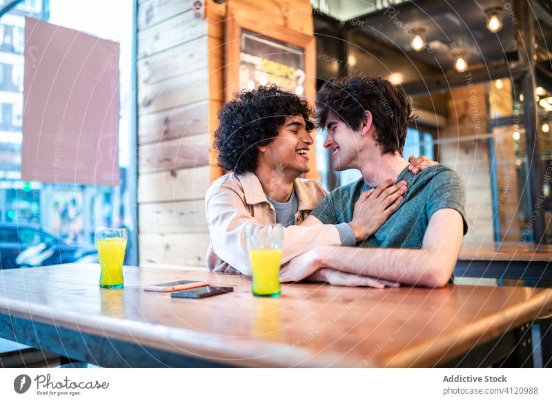 Multiethnisches schwules Paar flirtet während eines Dates im Cafe Flirten Termin & Datum Café Tisch Glück Zusammensein heiter Freund romantisch Zuneigung