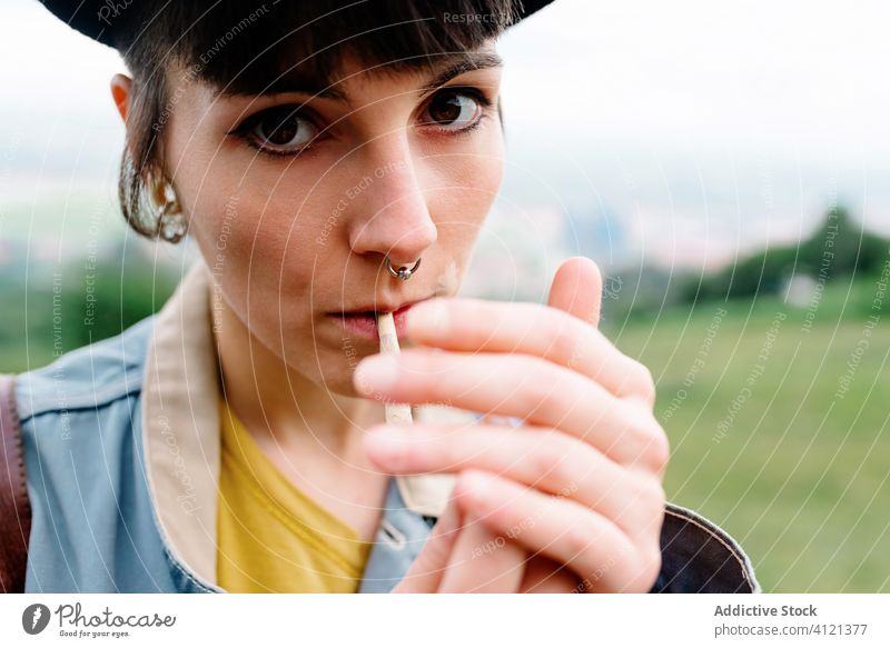 Junge Frau raucht Zigarette auf der Straße cool Rauch Habitus Piercing Menschliches Gesicht Subkultur informell modern Make-up Nase Süchtige Tabak jung lässig