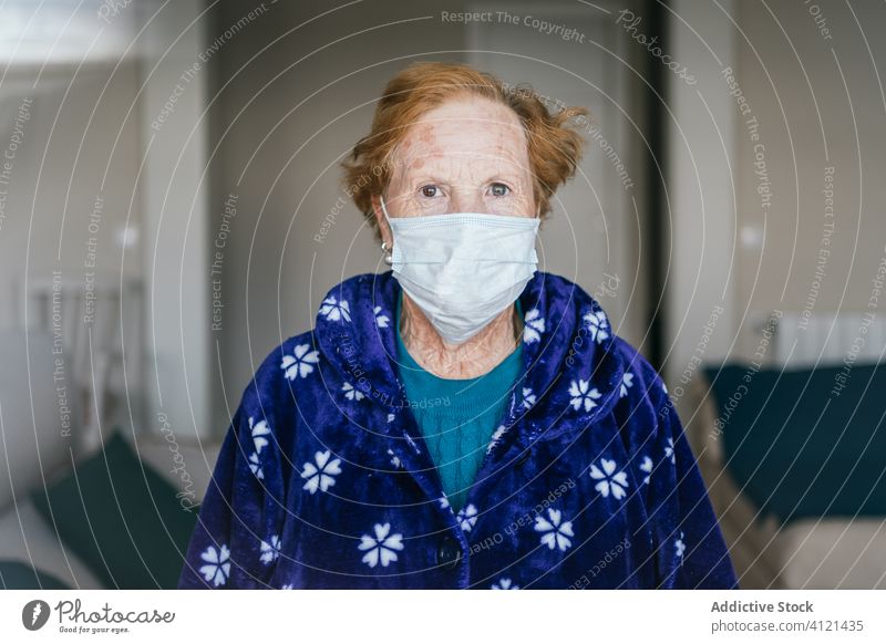 Ältere Frau mit medizinischer Maske steht und schaut in die Kamera Krankenhaus Mundschutz Infektion Krankheit Virus behüten Raum Risiko Menschengruppe Klinik