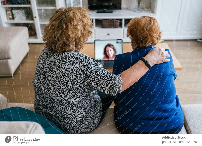 Frauen, die zu Hause Videogespräche am Laptop führen Videoanruf heimwärts Senior Sitzung benutzend online Freund heiter sich[Akk] sammeln gealtert Kommunizieren