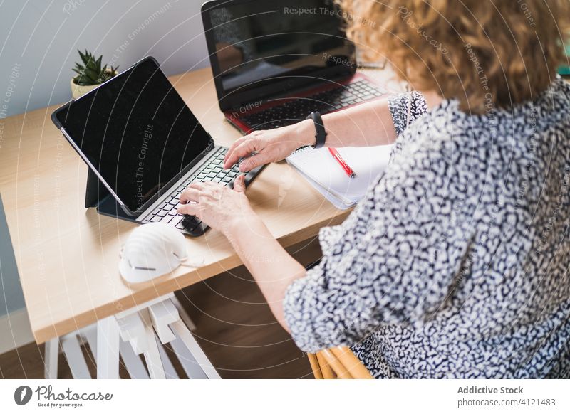 Anonyme Frau, die zu Hause am Schreibtisch an Laptops arbeitet Tippen Keyboard Tisch heimwärts Arbeit benutzend Internet Browsen Computer Netbook Business