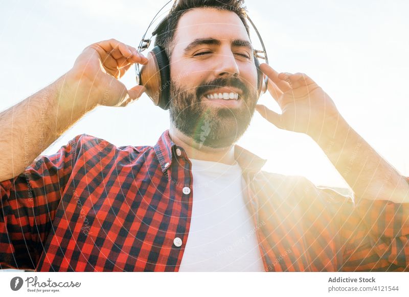 Junger Mann hört zu Hause Musik jung Lifestyle außerhalb Typ Telefon Technik & Technologie Mobile Kopfhörer im Freien männlich Funktelefon Erwachsener lässig