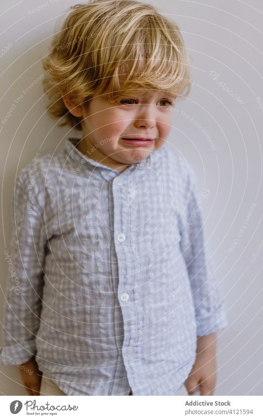 Trauriger Junge weint in modernem Studio weinen enttäuschen wenig Kind traurig unanständig jammern lässig Kindheit Gesichtsausdruck bezaubernd niedlich Hemd