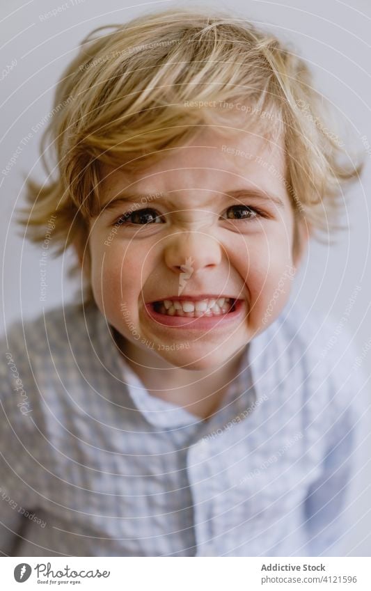 Freudig lächelnder und in die Kamera zeigender Junge Lächeln Freude wenig Kind bezaubernd Inhalt heiter Optimist niedlich Kindheit positiv lässig