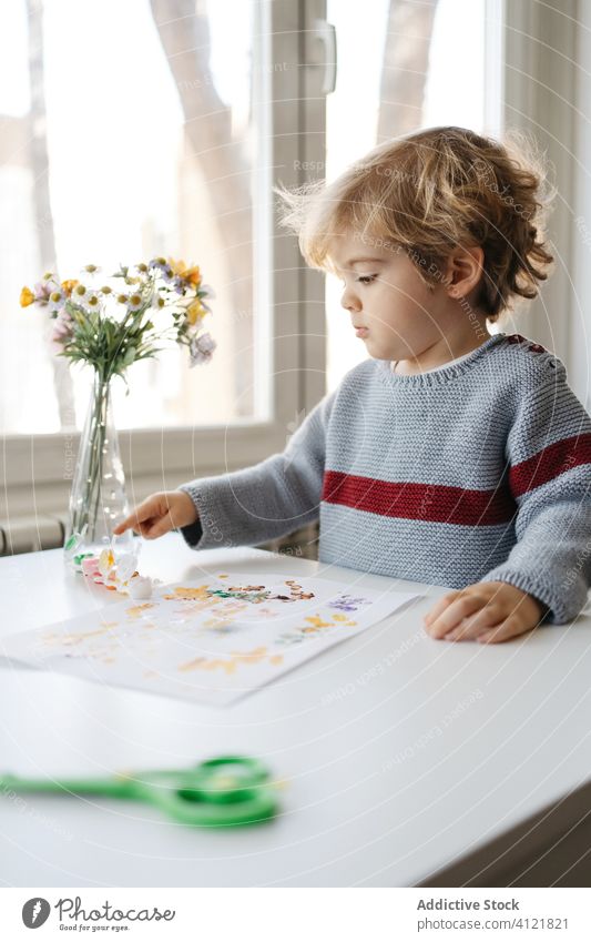 Blondes Kind verwendet Gouache für Fingermalerei zu Hause Junge Farbe zeichnen kreativ heimwärts Kindergarten kleben Zeichnung Papier wenig niedlich bezaubernd