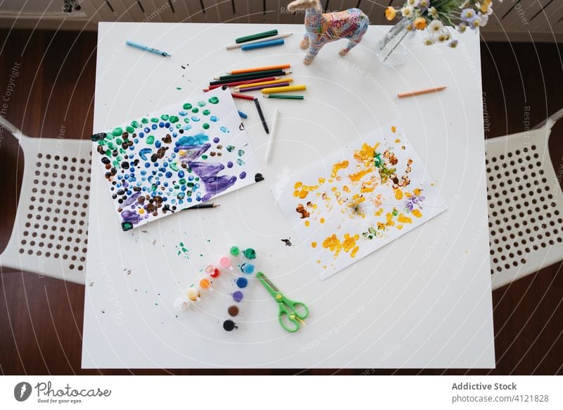 Von oben Tisch mit Bildern und Kunstwerkzeugen zu Hause Farbe Werkzeug Vorschule lernen farbenfroh heimwärts Wasserfarbe Palette Schlamassel Bleistift Schere