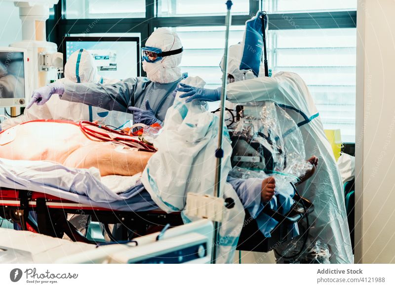 Ärzte in Schutzuniform bei der Arbeit im Operationssaal eines Krankenhauses Arzt Klinik viral geduldig Pflege Infektion Gerät Leckerbissen Spezialist Mundschutz