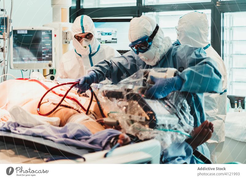 Ärzte in Schutzuniform bei der Arbeit im Operationssaal eines Krankenhauses Arzt Klinik viral geduldig Pflege Infektion Gerät Leckerbissen Spezialist Mundschutz