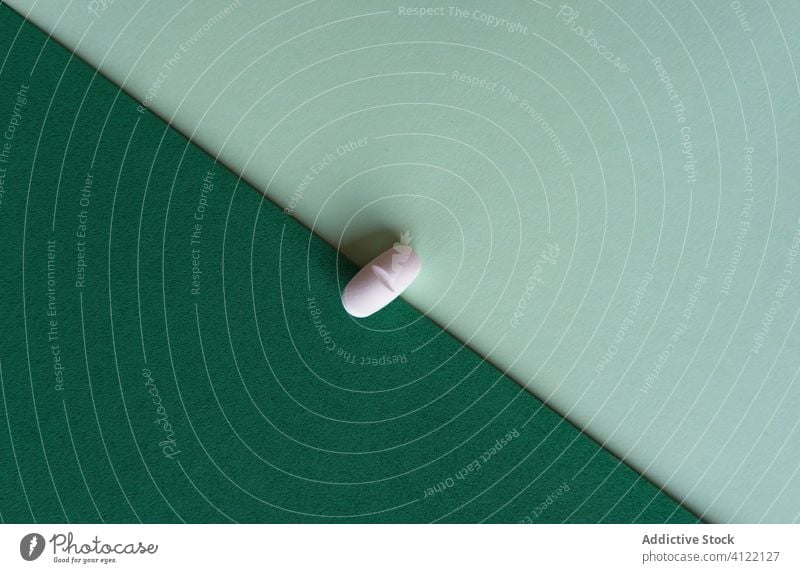 Weiße ovale Pille auf grünem und türkisem Tisch Tablette Leckerbissen Verschreibung Medizin Medikament sehr wenige Grippe Oval Krankheit medizinisch krank