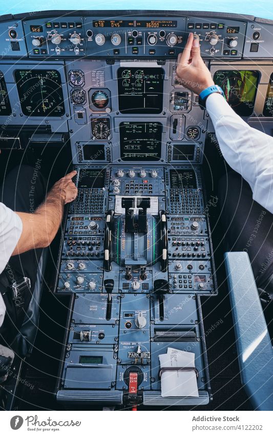 Piloten, die während des Fluges im Cockpit arbeiten Männer Flugzeug Kontrolle Armaturenbrett Gerät Flieger männlich Kapitän prüfen modern Fluggerät Ebene