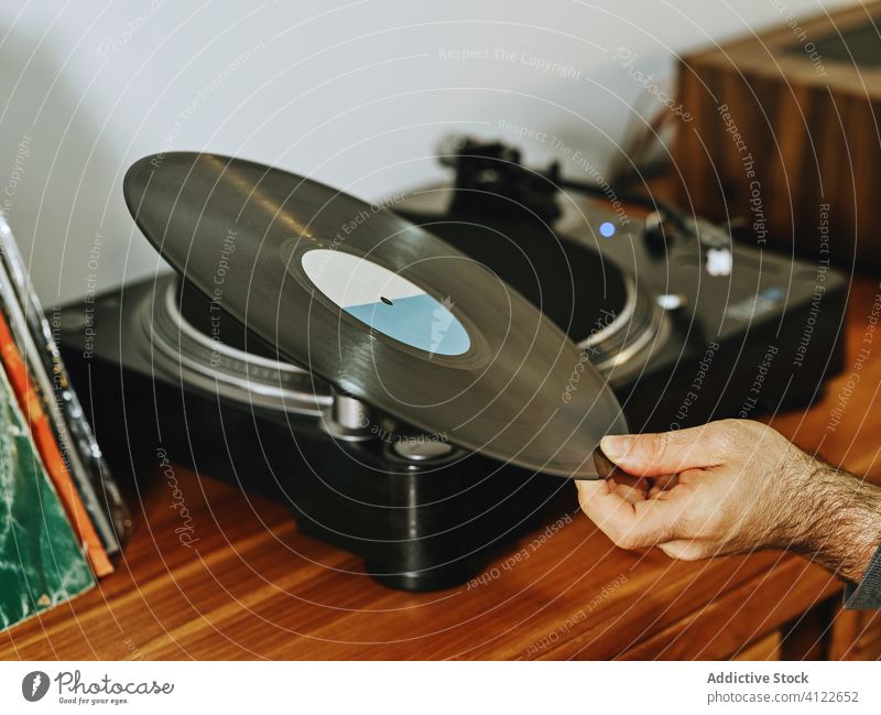 Anonyme Person, die Musik auf einem Schallplattenspieler hört Vinyl Aufzeichnen Scheibe Plattenteller Spieler retro altehrwürdig Nostalgie zuhören Kälte
