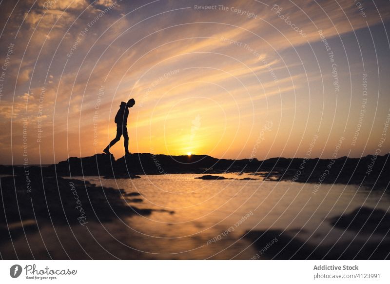 Unbekannte Person, die bei Sonnenuntergang am Wasser spazieren geht Ufer Himmel Abend Silhouette hell Fuerteventura Spanien Kanarische Inseln Windstille