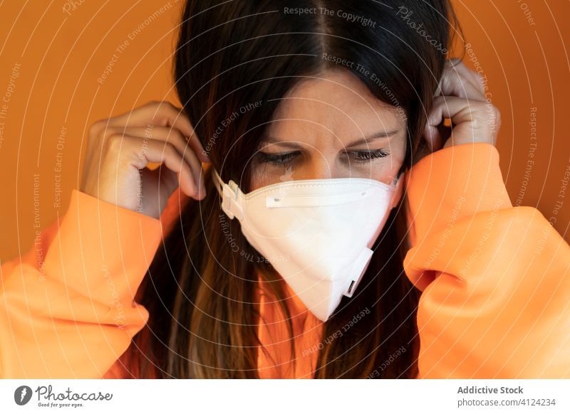 Frau setzt Schutzmaske auf Mundschutz behüten Coronavirus COVID verhindern sicher Gesundheitswesen Pandemie jung lässig angezogen Bund 19 COVID19 Infektion