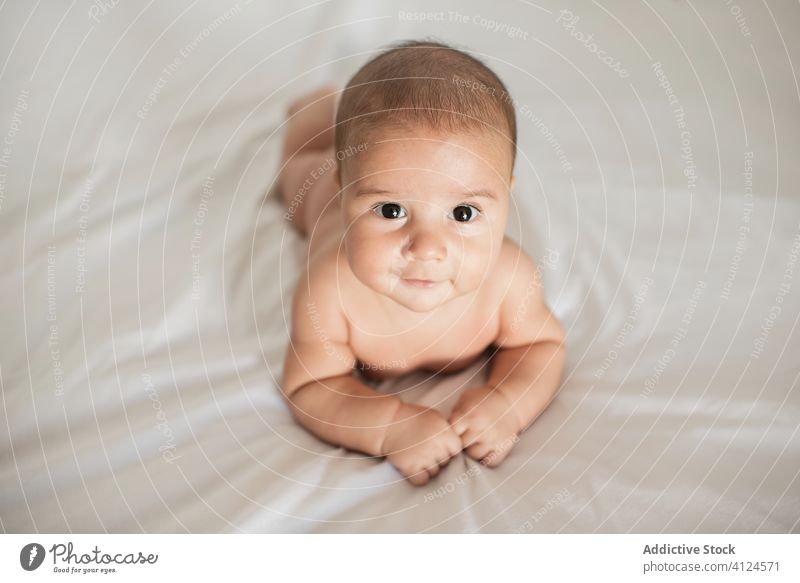 Niedliches Baby auf dem Bett liegend zu Hause Lügen heimwärts niedlich gemütlich Lächeln weich Komfort sich[Akk] entspannen Säugling bezaubernd unschuldig