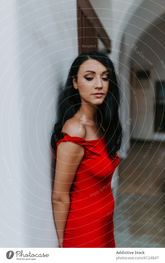 Junge Frau in rotem Kleid in der Nähe eines weißen Gebäudes Stil Wand die Arme verschränkt elegant attraktiv jung Model schlank schön hübsch trendy traumhaft