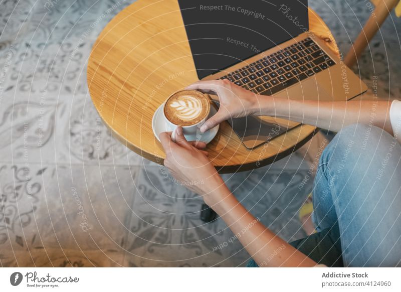 Erwachsene Frau trinkt aromatischen Kaffee, während sie zu Hause am Laptop arbeitet freiberuflich benutzend Café schäumen Internet Latte trinken Tasse heimwärts