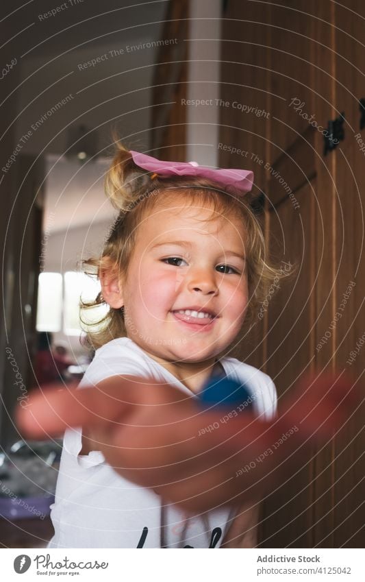 Fröhliches kleines Mädchen zeigt Knetmasse in die Kamera Spielzeug Modellierung Ton manifestieren Ergebnis handgefertigt zeigen Glück stolz charmant heimwärts