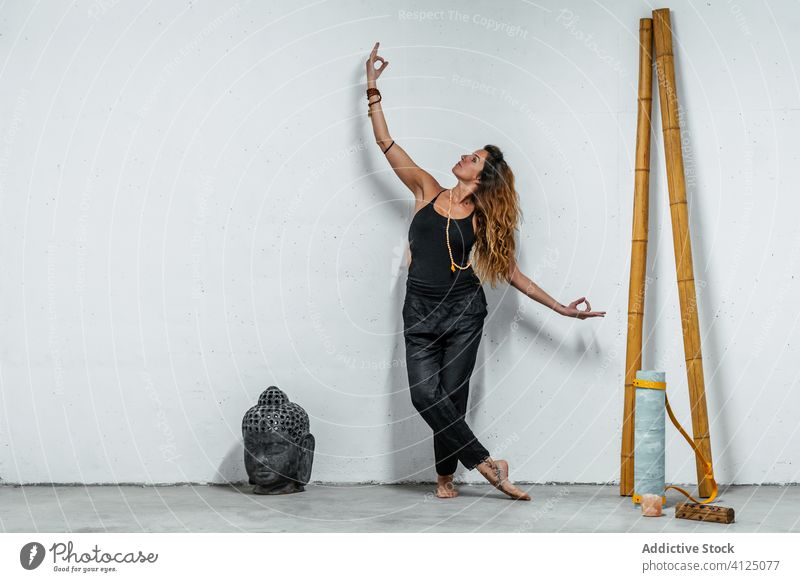 Frau mit Mudra-Geste im Studio gestikulieren Yoga Asana Buddha ruhig Sportbekleidung üben Konzentration meditieren Windstille Gelassenheit Pose beweglich
