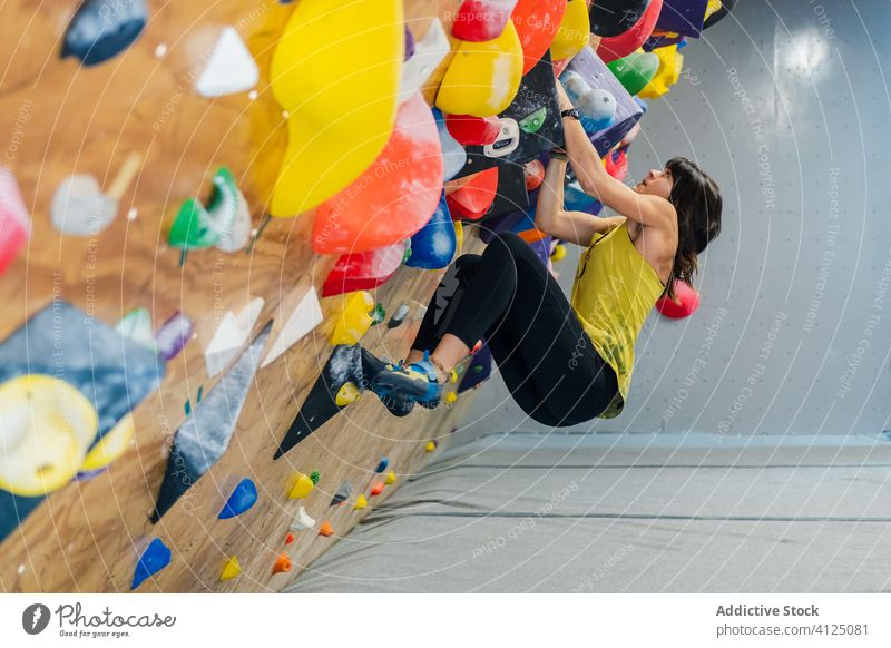 Frau klettert auf Wand Aufstieg Sport Training Felsbrocken Hobby Gerät Fitnessstudio Aktivität Athlet extrem stark Übung anstrengen aktiv Felsen hängen