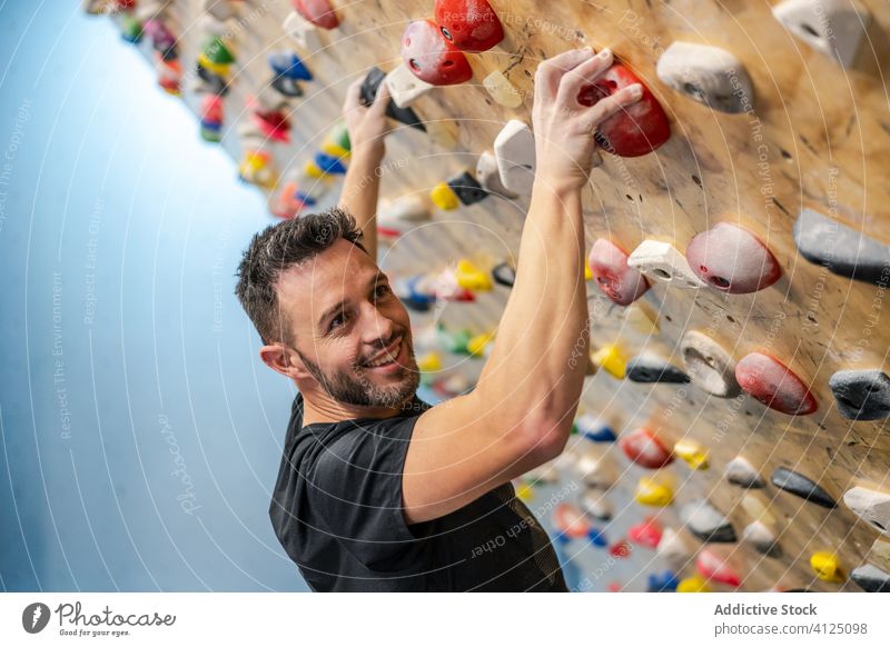 Mann übt Klettern an der Wand Aufstieg Sport Training Felsbrocken Hobby Gerät Fitnessstudio Aktivität Athlet extrem männlich Übung anstrengen Stärke Felsen