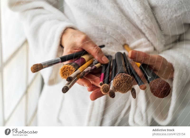 Frau im Bademantel mit Schminkpinseln Make-up Bürste Kosmetik Werkzeug Hautpflege Schönheit Ton weich gemütlich Leckerbissen frisch Gesicht perfekt