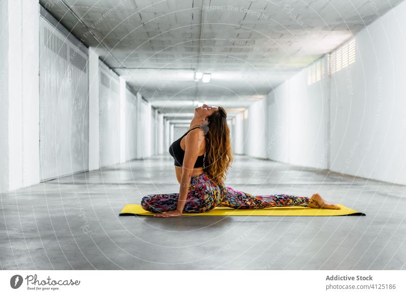 Frau praktiziert Yoga auf der Matte üben Tauben-Yoga eka pada rajakapotasana Pose Unterlage Körperhaltung positionieren Gleichgewicht Augen geschlossen