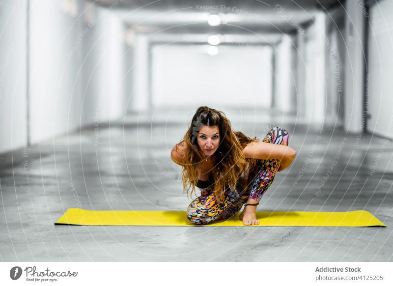 Schlanke Frau beim Üben einer fortgeschrittenen Yoga-Asana üben weitergeben Pferch sitzen Pose positionieren marichyasana beweglich Garage Herausforderung