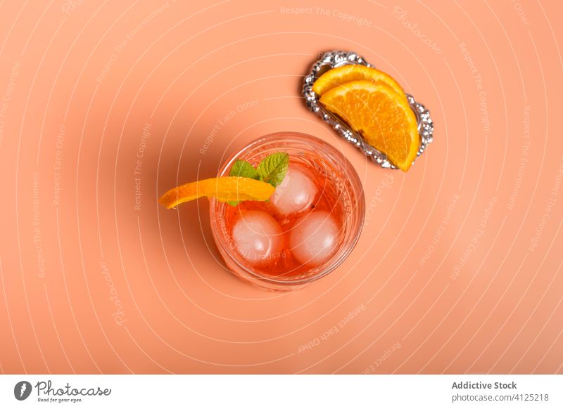 Erfrischungscocktail mit Orangenscheiben und Minze Glas Cocktail Alkohol orange Eis Würfel Scheibe Zweig Blatt grün Frucht reif Rum Getränk trinken Kristalle