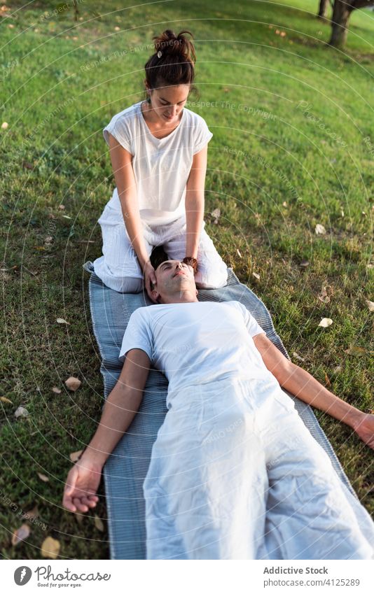 Entspanntes Paar meditiert auf grünem Gras Yoga meditieren Lügen Unterlage Zusammensein Augen geschlossen Harmonie Wiese Windstille Pose Feld geistig Massage