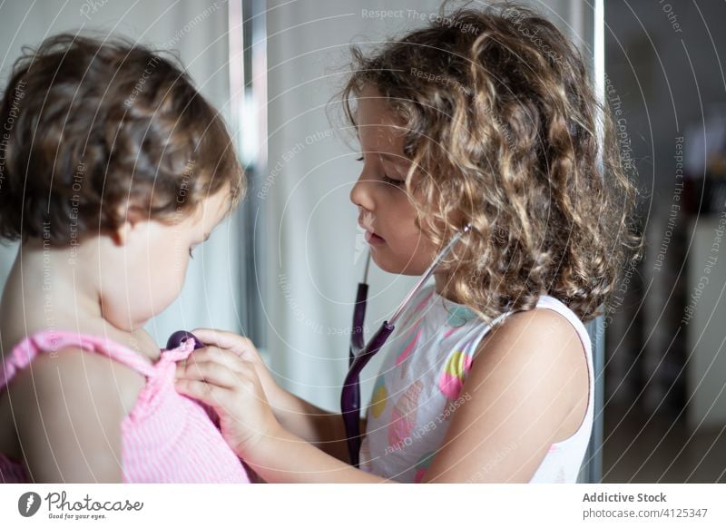 Kleines Mädchen untersucht die Lunge ihrer Schwester mit einem Stethoskop Klinik Kinder untersuchen wenig besuchen Krankenhaus Pflege Arzt bezaubernd