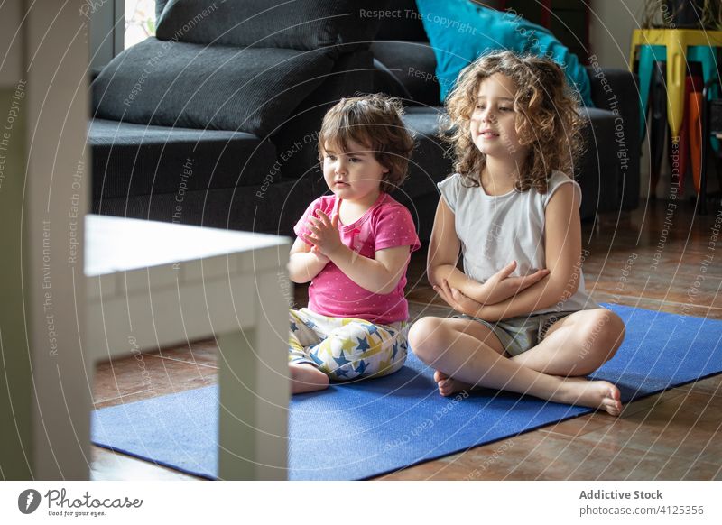 Kleine Kinder machen Yoga zu Hause üben Zusammensein heimwärts wenig Schwester Lotus-Pose positiv Gesundheit Energie genießen zuschauen Video Tutorial Wellness