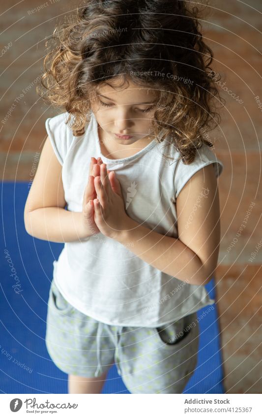 Kleines Kind macht Namaste-Geste beim Yoga üben heimwärts Mädchen Gebet Pose Windstille ruhig gestikulieren Unterlage wenig Gesundheit Energie Frau meditieren