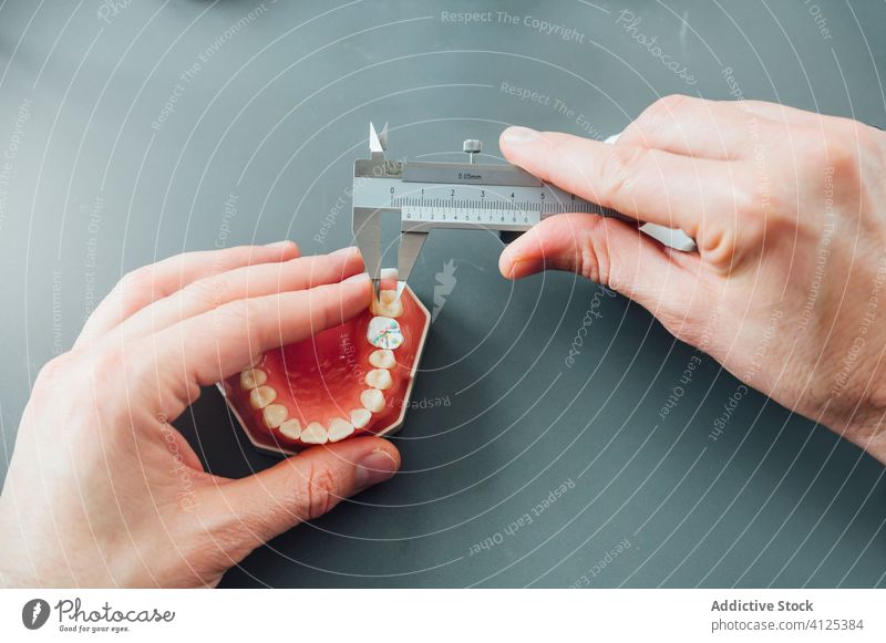 Zahnmedizinstudent misst Zahn während des Unterrichts messen Prothesen Werkzeug Schieblehre Kiefer Medizin Gerät lernen professionell Tisch Instrument