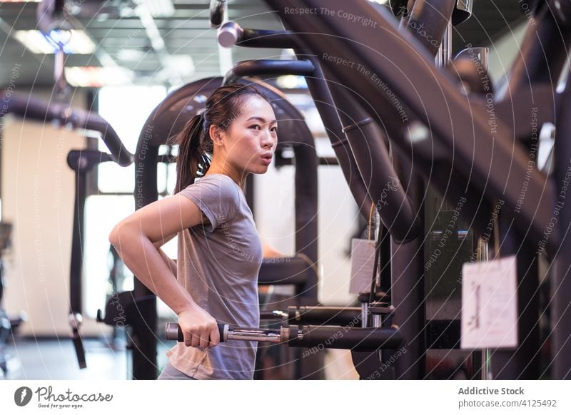 Starke ethnische Sportlerin trainiert an einem Trainingsgerät in einem modernen Fitnessstudio Frau Gerät Dip Trizeps Bar Fokus Wohlbefinden Übung Maschine