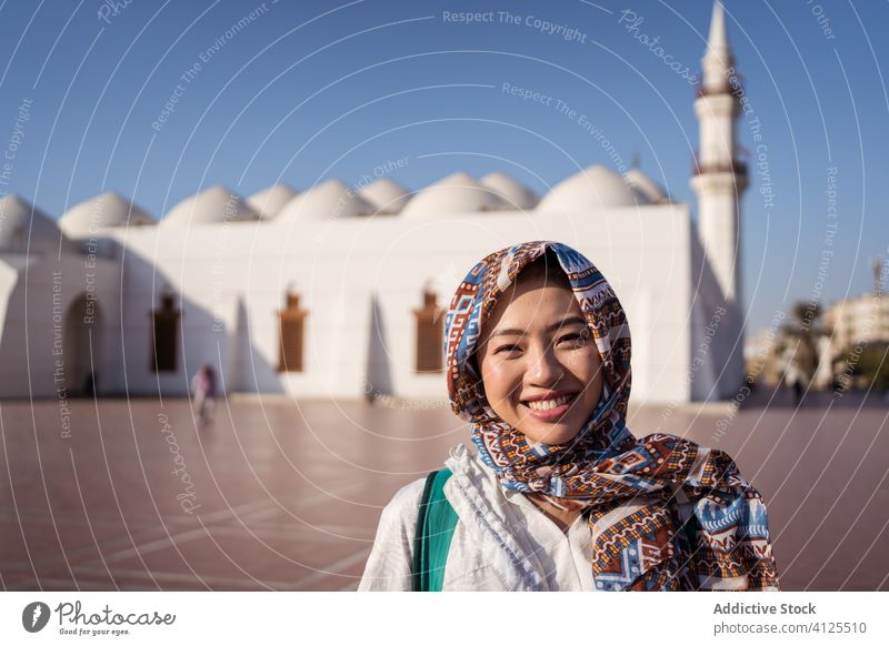 Ethnische Frau stellt sich gegen islamische Moschee Glück jung Straße Lächeln Tradition Religion Islam positiv ethnisch asiatisch Sightseeing Saudi-Arabien