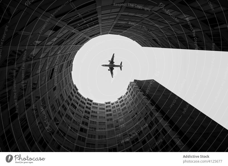 Flugzeug fliegt über modernes Gebäude am Himmel in der Stadt Fluggerät urban Architektur rund einfangen Megapolis Verkehr Großstadt reisen Freiheit Zeitgenosse