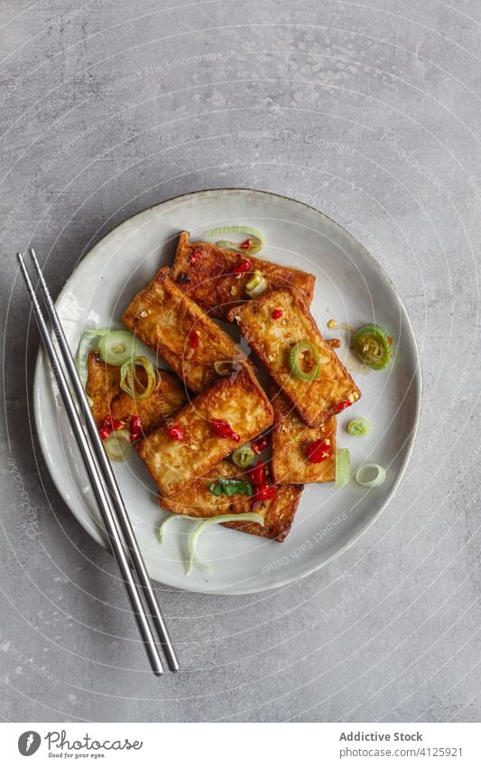 Tofu-Scheiben in Sojasauce auf dem Tisch Vegetarier Koch marinieren Essstäbchen Rezept Knoblauch Teller Handtuch Asiatische Küche duftig Stahl Lebensmittel