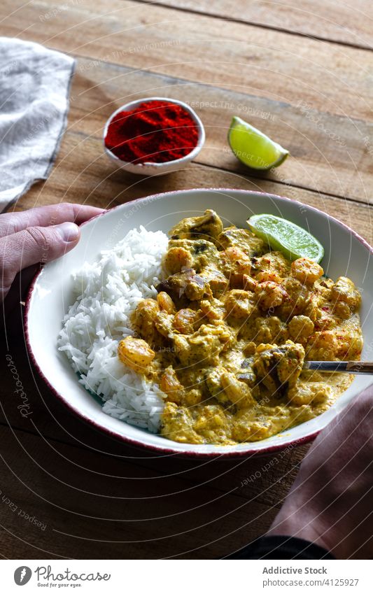 Erntehelfer isst leckeres Curry aus Pilzen und Garnelen Mann essen geschmackvoll Würzig Reis Granele Indisches Essen männlich Küche Kalk Scheibe lässig anhaben