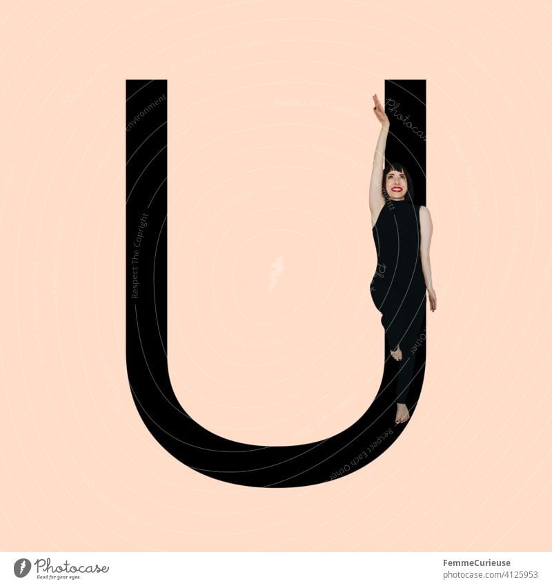 Grafik zeigt schwarzfarbigen Buchstaben U des lateinischen Alphabets vor hautfarbenem Hintergrund und integrierter fotografischer Ganzkörperaufnahme einer posierenden brünetten Frau mit Bob Frisur in schwarzem Einteiler