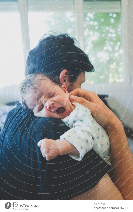 Junger alleinstehender Vater, der sich um sein neugeborenes Baby kümmert Papa Familie Single Elternschaft Säuglingsalter Neugeborene Pflege neue Männlichkeit