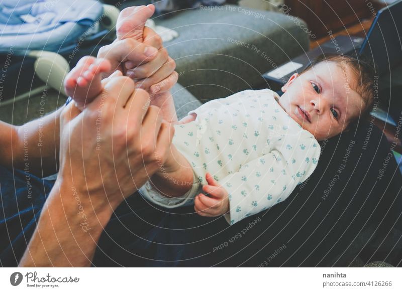 Neugeborenes Baby liegt auf den Beinen des Vaters Papa neugeboren Familie Single Elternschaft Säuglingsalter Pflege neue Männlichkeit modern Vaterschaft