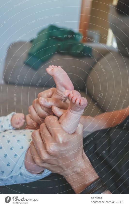 Junger Papa berührt sein Baby Füße verfrüht übungen Beine Gewicht heimwärts neugeboren Neugeborene Säugling Kindheit Fuß Pflege fürsorglich dünn Zehen wenig