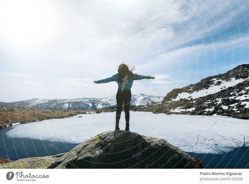 Silhouette Frau genießt die Natur in der Spitze der verschneiten Berge mit einem gefrorenen See vor ihr. Winterlandschaft Berge u. Gebirge Schnee wandern
