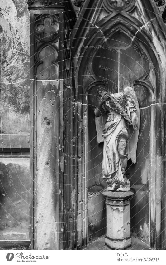 ein Engel mit Spuren des Krieges auf einem Friedhof Berlin Schwarzweißfoto Außenaufnahme cemetery Menschenleer Grabstein Tod Trauer Vergänglichkeit Grabmal