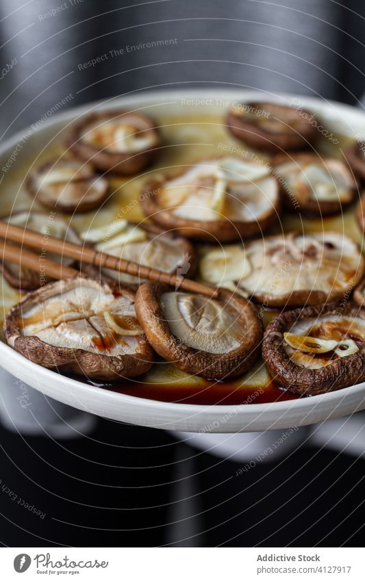 Leckere gebackene Champignons mit Knoblauch in Sojasauce Pilz Lebensmittel Mahlzeit Shiitake Saucen Teller Essstäbchen Abendessen Gastronomie Ernährung Küche