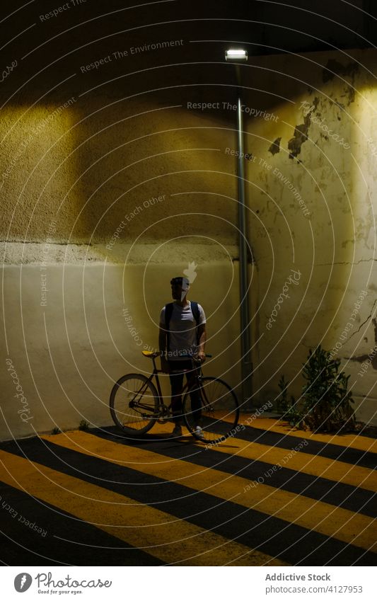Unbekannter Mann mit Fahrrad bei Nacht Fixie Zyklus urban Rad feststehend Sport Transport Ausrüstung Lifestyle Wand Straße Hipster Mitfahrgelegenheit Pedal
