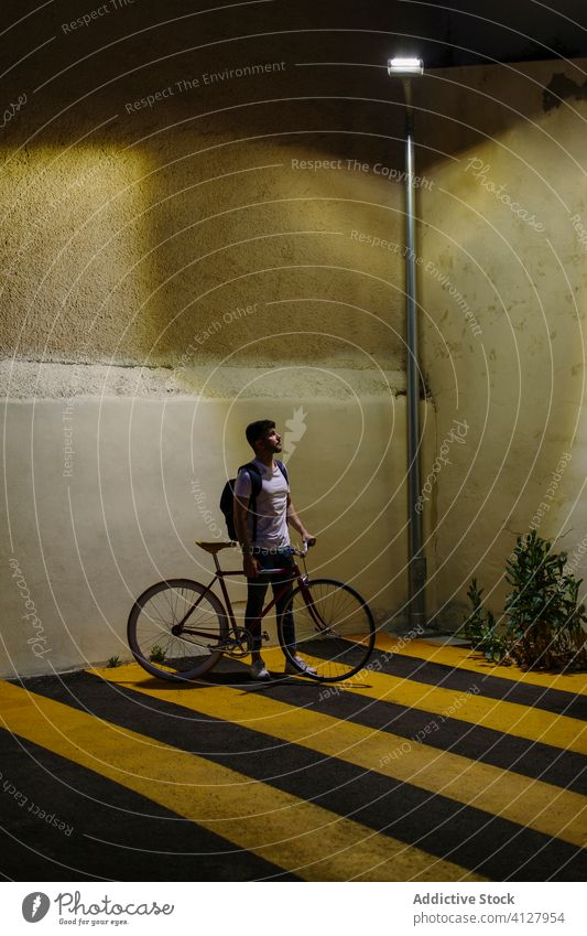 Mann schaut auf die Straßenlaterne mit einem Fahrrad Fixie Zyklus urban Rad feststehend Sport Transport Ausrüstung Lifestyle Wand Hipster Mitfahrgelegenheit