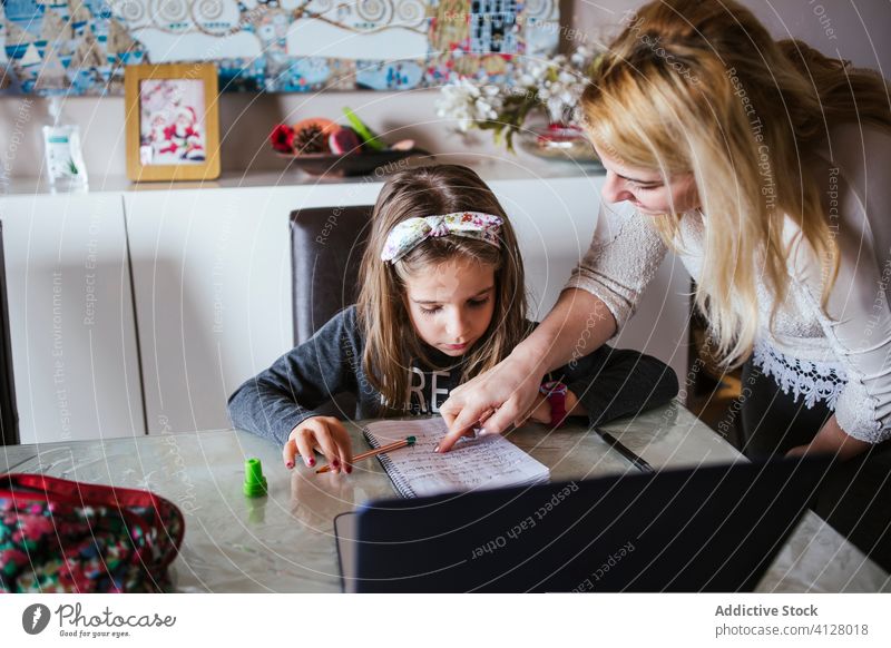 Mutter hilft Tochter bei den Hausaufgaben Hilfsbereitschaft heimwärts Anweisung Notebook Punkt Raum gemütlich Mädchen Frau Aufgabe Kind Eltern Notizblock