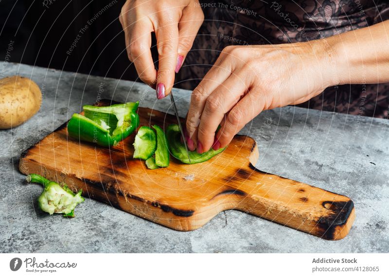 Köchin schneidet Paprika in der Küche geschnitten Schneidebrett Frau Koch hacken Hausfrau Messer vorbereiten frisch Tisch Lebensmittel ungekocht kulinarisch