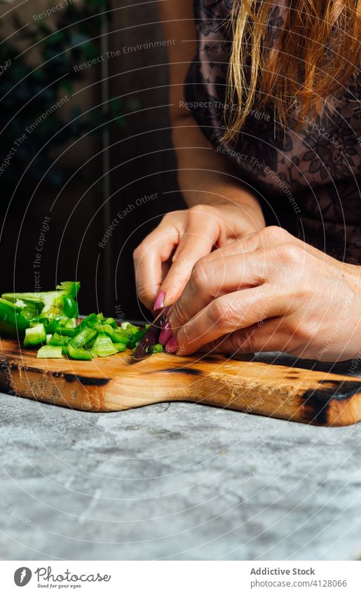 Köchin schneidet Paprika in der Küche geschnitten Schneidebrett Frau Koch hacken Hausfrau Messer vorbereiten frisch Tisch Lebensmittel ungekocht kulinarisch
